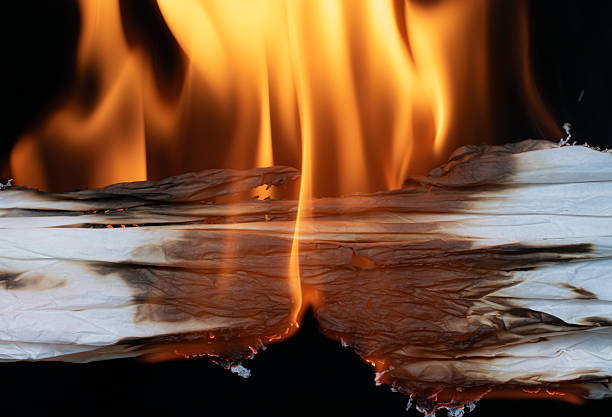 istock burning white paper, glowing edge of paper on a black background 2228548491