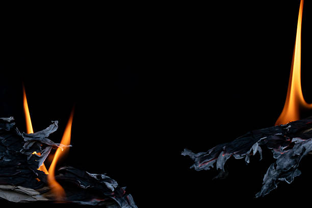 burning grey paper, glowing edge of paper on a black background