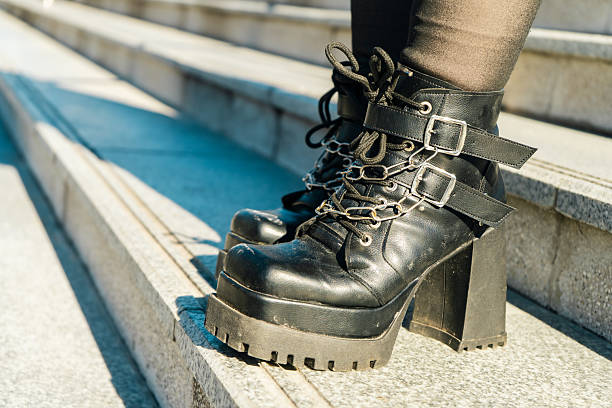 Close-up of stylish black platform boots with chains and buckles, showcasing urban fashion
