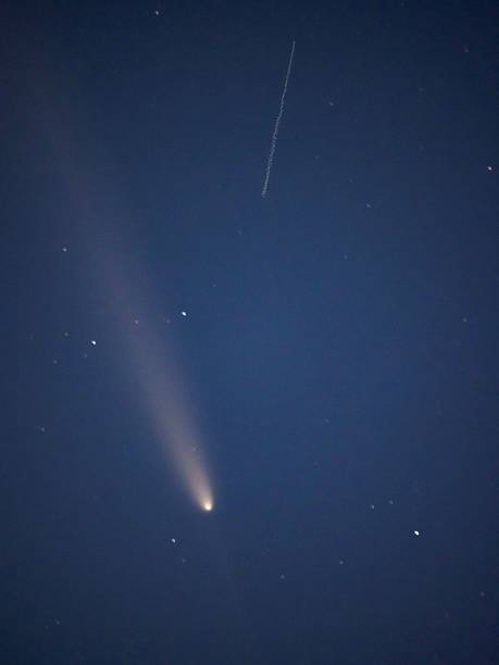 istock Comet with a bright tail in the night sky. 2228550312