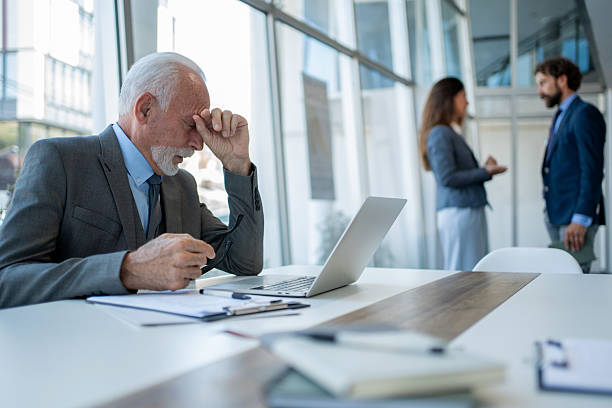 istock Senior businessman suffering headache at work in office 2228551048