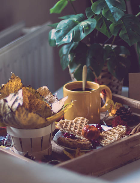 Wooden tray with breakfast and a garland on the bedside table.