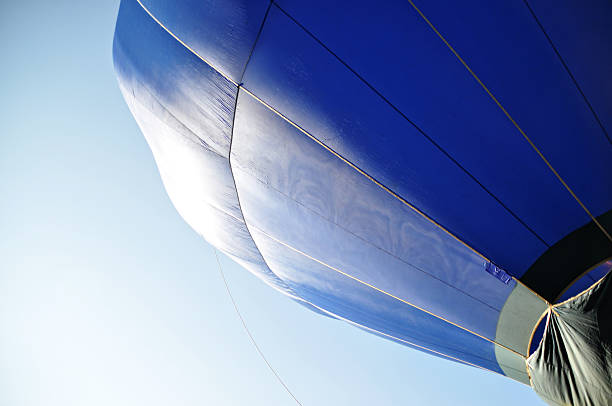 A striking blue hot air balloon soaring through the sky, harmonizing with the endless blue above and capturing the essence of serene flight.