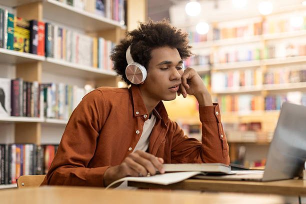 istock Tired bored black male university student sleeping while sitting at desk in library, exhausted of preparing for exam and suffering of lack of sleep 2228552545