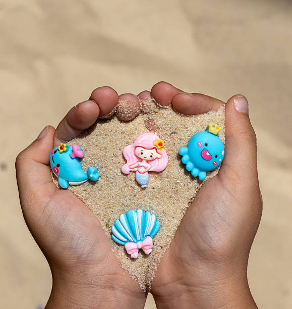 istock Playful Hands Holding Adorable Miniature Sea Creatures and Shells 2228552699