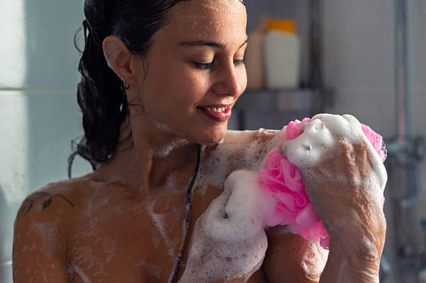 istock Young happy woman taking a shower 2228554582