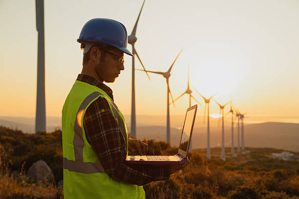 istock Portrait of Engineer Using Laptop at Wind Farm During Sunset Symbolizing Sustainability and Artificial Intelligence in Renewable Energy 2228556343