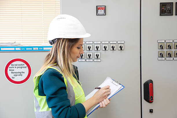 istock Female Engineer Inspecting Control Panel and Taking Notes for Safety and Maintenance at Power Station 2228557596