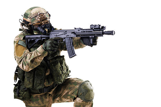 istock Tactical soldier in camouflage aiming rifle isolated on white background 2228558319