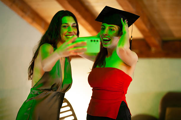 istock Two friends celebrating a graduation by taking a selfie together 2228558641