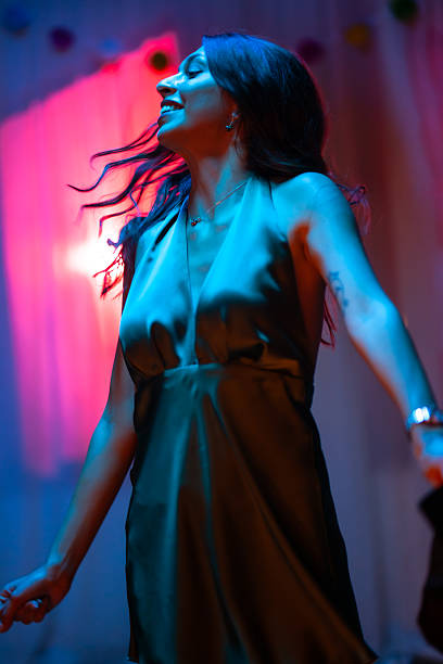 istock Young woman dancing joyfully at a vibrant celebration during nighttime 2228558711