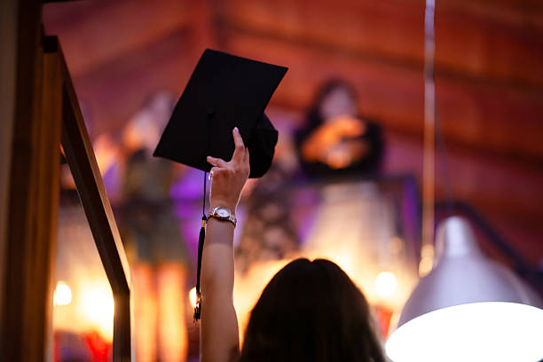 istock Graduate celebrates with raised cap in vibrant indoor environment 2228558749
