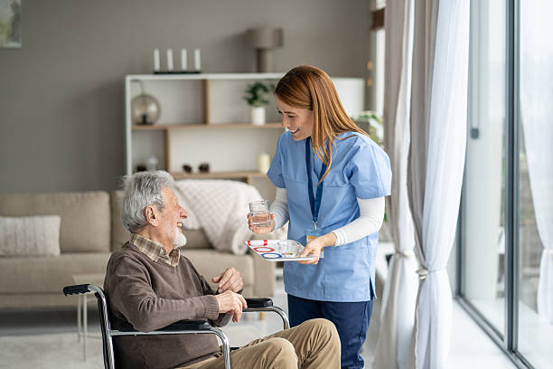 istock Cheerful Nurse Helping Elderly Patient with Water Glass 2228558886
