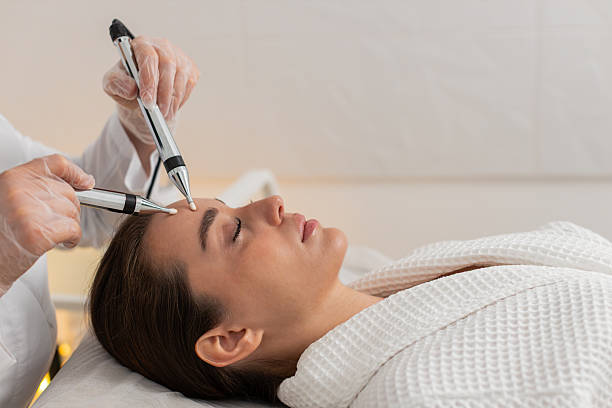 istock Beautician doctor makes woman micro currents face therapy using electrical impulses in spa salon 2228559165