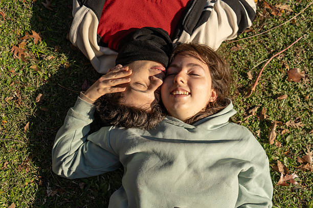 istock Young couple relaxing together on grass in autumn sunlight 2228561042