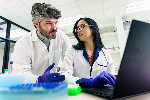 istock Latin american scientists collaborating on research using laptop in laboratory 2228562022