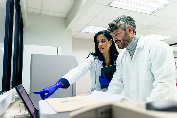 istock Latin american scientists analyzing data on laptop in laboratory 2228562047