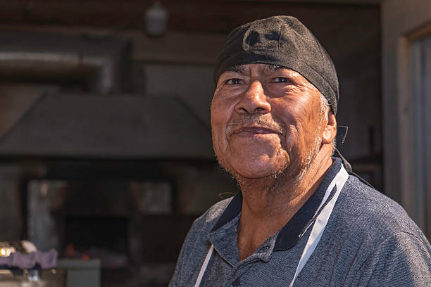 istock Senior baker smiling in a bakery in mexico 2228564091