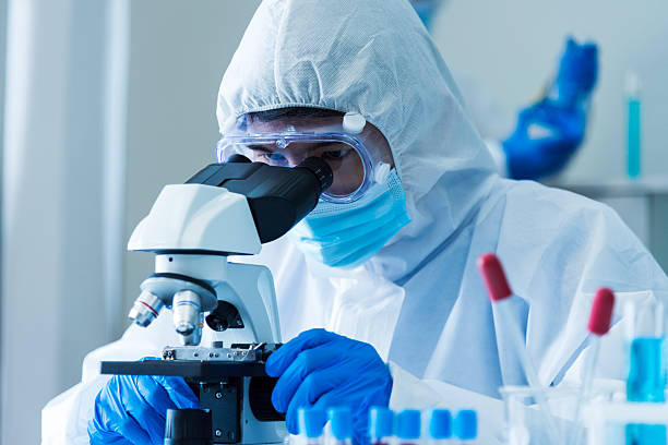 istock Scientist man look into Microscope research in science laboratory. Asian scientist look at microbiology microscope laboratory equipment chemistry lab. Biochemistry research experiment vaccine concept 2228569387