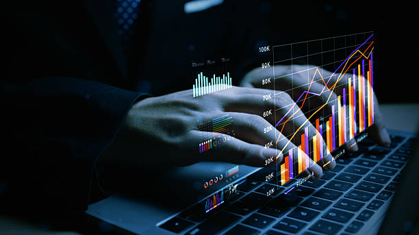 istock Close-up of hands typing with overlaid financial charts and data analysis, representing business intelligence, digital analytics, and corporate growth. 3d Rendering 2228570563