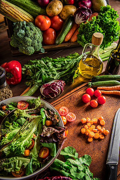 istock Making a vegan salad in rustic kitchen with assorted organic vegetables. Natural window lighting 2228574406