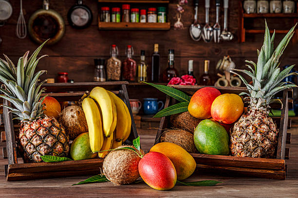 istock Wooden crates with assorted tropical fruits in rustic kitchen. Natural window lighting 2228574411