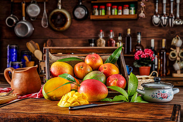 istock Group of mangos on a cutting board in a rustic kitchen. Natural window lighting. 2228574497