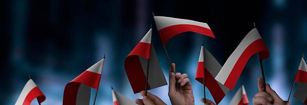 istock Poland flags in their hands on a blurred urban background 2228575150