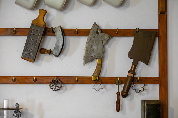 istock Vintage kitchen tools and meat cleavers hanging on a wooden rack in a rustic interior 2228580888