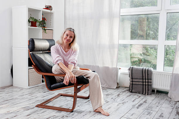 istock Happy middle aged Woman sits at Home 2228582129