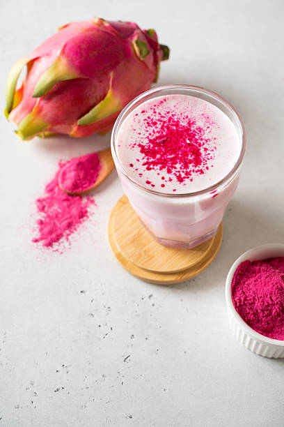 Pink matcha latte with powder on white background