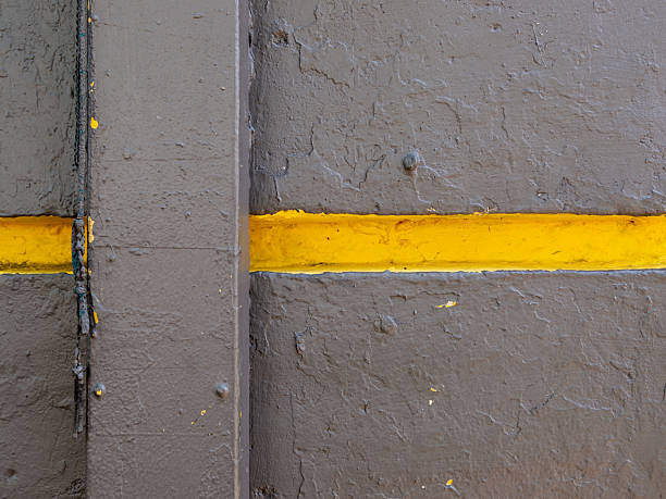 Dark grey walls rough surface with yellow paint groove lines.