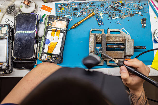Father and son determinate to build computer together using computer parts at home while asking for advice using smart phone