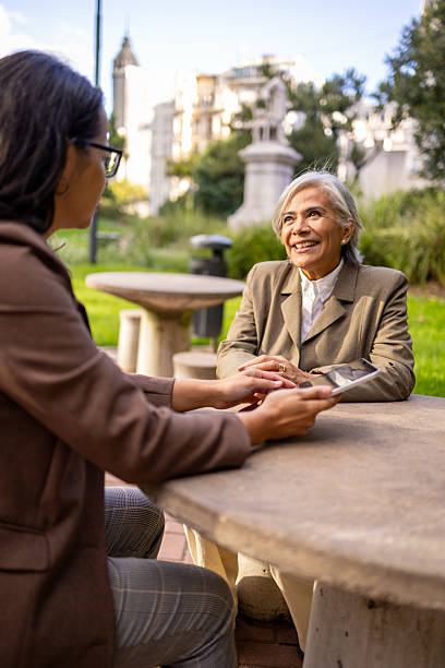 istock Two businesswomen discussing work plans outdoors at a city park 2228598683
