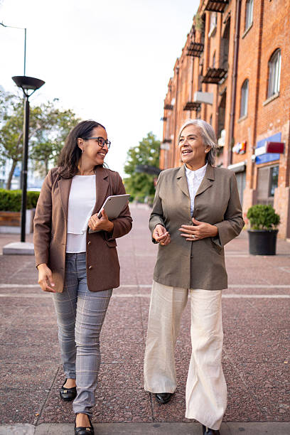istock Two professional women exchanging ideas while walking in an urban area 2228598696