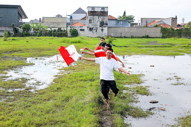Young Indonesian Parade, Waving Their National Flags In Celebration Of Independence Day.