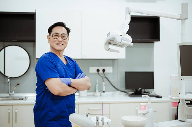 istock Smiling Male Dentist Standing in Bright Dental Practice. 2228601599