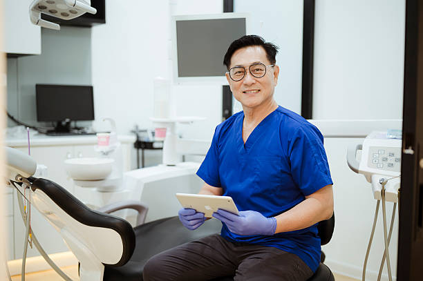 istock Middle-Aged Dentist Holding Digital Tablet and Looking at Camera. 2228601603