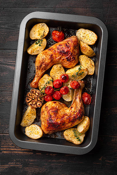 istock Chicken leg quarters baked with potatoes, tomatoes, garlic and herbs 2228602576