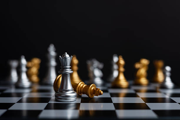 istock chess pieces The silver queen stood beside the fallen golden king 2228603368