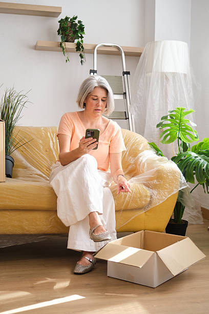 istock Woman organizing her new apartment using smartphone app after moving in 2228608219