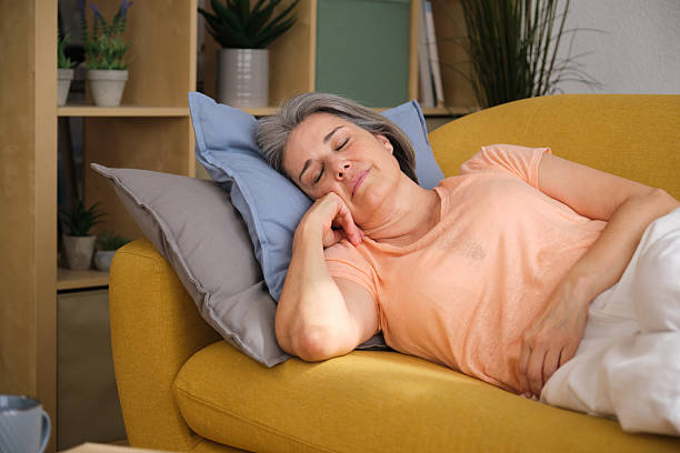 istock Senior woman sleeping peacefully on a comfortable sofa at home 2228609630