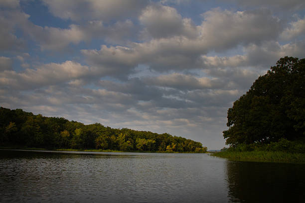 A beautiful lake scene in summertime in Oklahoma, pretty sky with fair weather white puffy clouds and trees on teh far shore