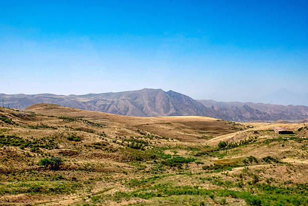istock Expansive mountainous landscape with rolling hills under clear blue sky 2228611466