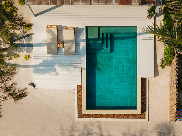 Top view of a luxury villa with a private pool on a tropical beach.