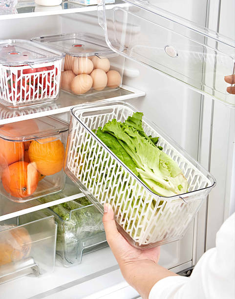 istock Fresh Produce Storage Organized Refrigerator with Clear Plastic Containers and Baskets, Woman taking fresh vegetables out of fridge, closeup. Dieting concept 2228611997