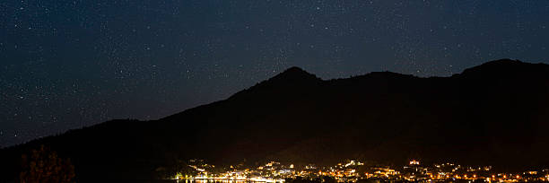 istock Seaside mountain resort town under a starry night sky. 2228612150