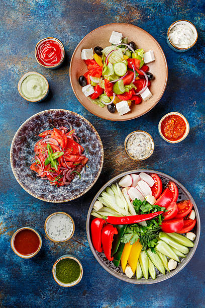 istock Dish with vegetables, peppers, tomatoes and greens, plates with vegetable salads and various types of sauces 2228616568