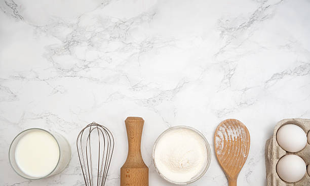 istock Baking essentials arranged on a marble countertop with flour, eggs, and milk for a delicious recipe preparation 2228617613