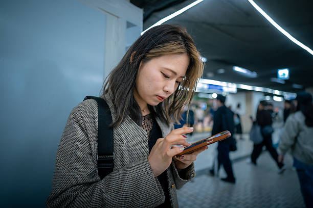 istock Young woman typing message on smartphone in night city 2228619247